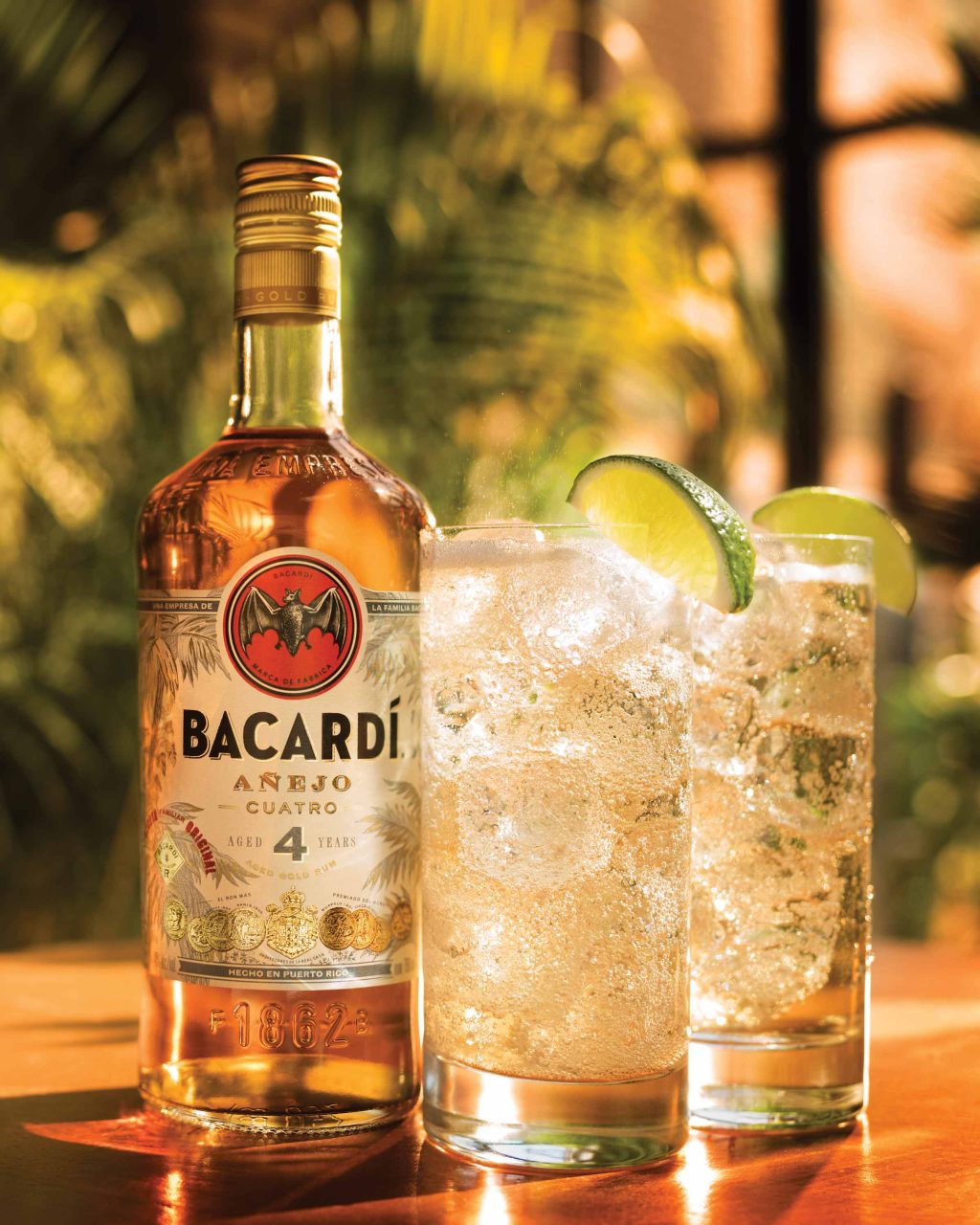 Пляшка рому Bacardi Añejo Cuatro та два келихи з льодом і лаймом