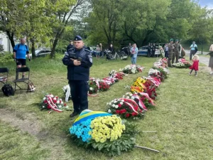 Поліцейський біля вінків з прапором України на меморіалі жертв нападів
