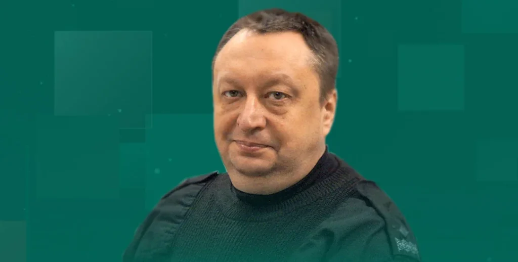 Чоловік середнього віку в чорному светрі на зеленому геометричному тлі