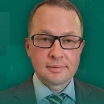 Чоловік у окулярах сірому костюмі та смугастому галстуку на зеленому фоні