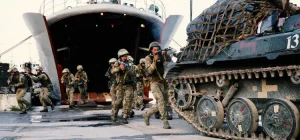 Морпіхи з автоматами вибігають з десантного корабля біля танка