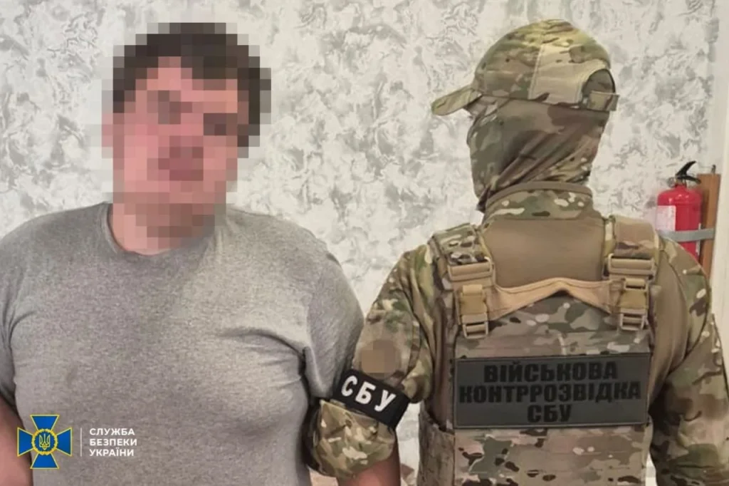 Співробітник військової контррозвідки СБУ в камуфляжі поруч із затриманим чоловіком